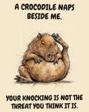 Capybara watercolor art print with the saying "A CROCODILE NAPS BESIDE ME. YOUR KNOCKING IS NOT THE THREAT YOU THINK IT IS."
