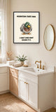 The same print shown hanging in a bathroom — frame for display only, not included