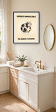 The same print shown hanging in a bathroom — frame for display only, not included