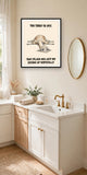 The same print shown hanging in a bathroom — frame for display only, not included
