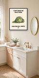 The same print shown hanging in a bathroom — frame for display only, not included