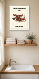 The same print shown hanging in a bathroom — frame for display only, not included