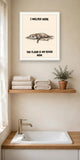 The same print shown hanging in a bathroom — frame for display only, not included