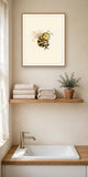 The wordless smug bee print in an oak frame on a bathroom wall above a wooden shelf — frame for display only, not included